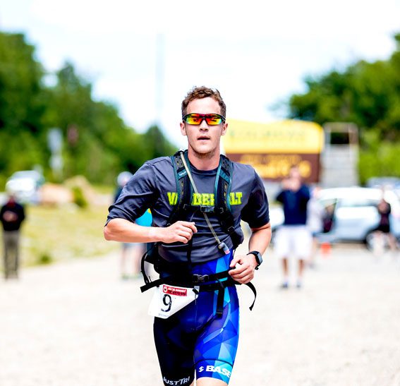 Male athlete runs near Wildcat Mountain sign during Sea 2 Summit Triathlon