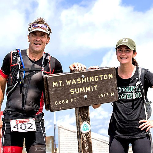 Two athletes stand at Mt Washington summit during Sea2Summit Triathlon